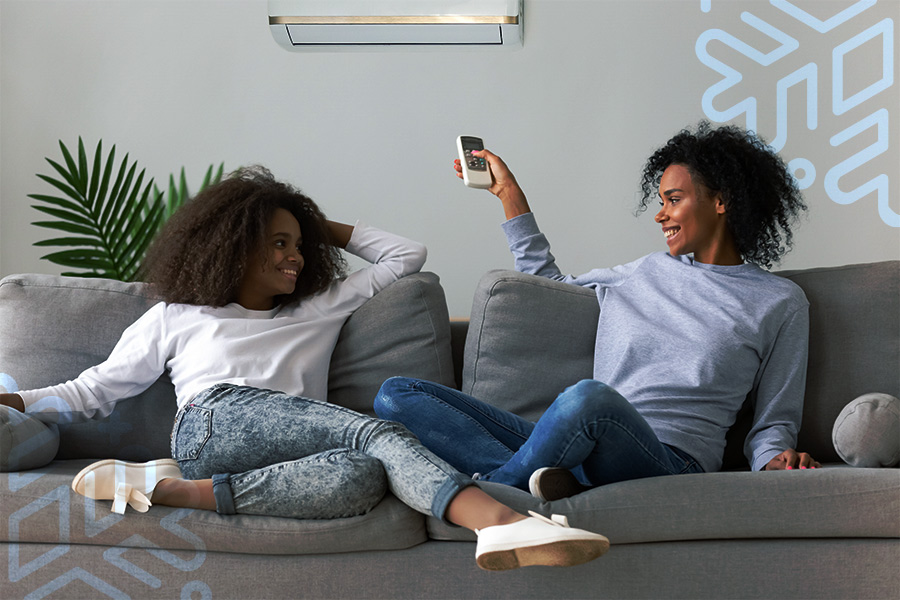 mother and daughter enjoying air conditioner in living room