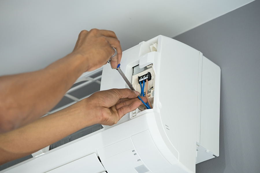 technician hands close up with screwdriver repairing ac barrett tx